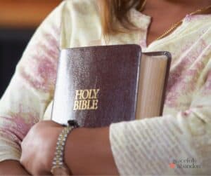 woman hugging bible/ holding fast to Scripture