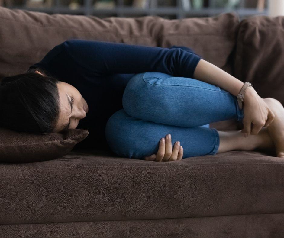 woman laying on a couch after a miscarriage; wondering why God doesn't answer prayer